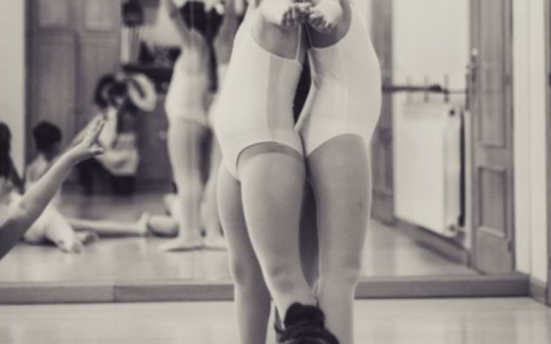 Foto en blanco y negro de tres niñas en maillot de danza frente a espejo