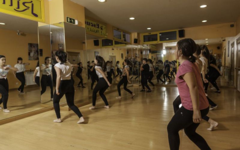 Grupo de niños bailando frente a gran espejo