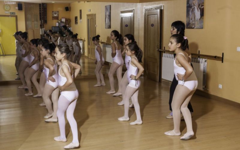 Grupo de niñas en aula de danza con maillot blanco