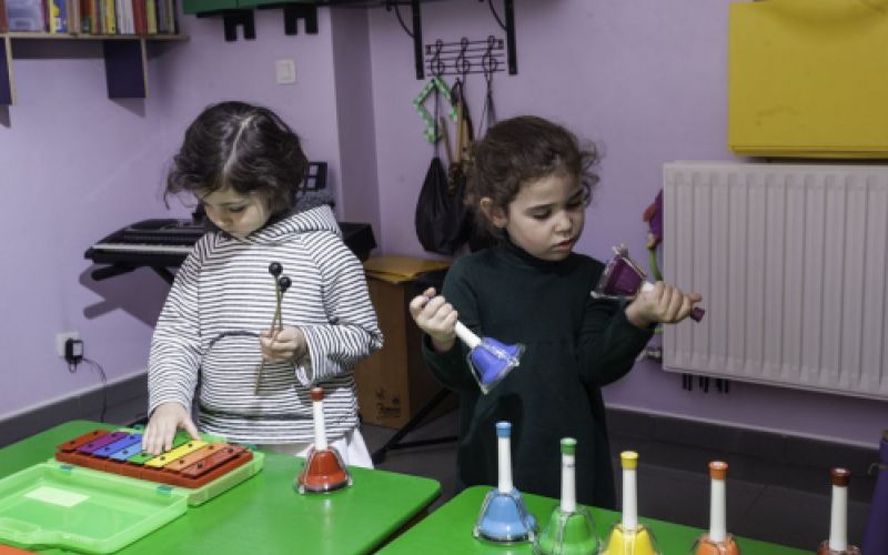 Dos niñas en aula con diferentes instrumentos de percusión
