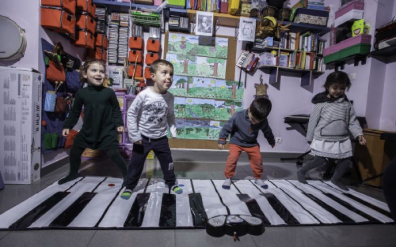 Cuatro niños pequeños tocando un teclado de piano de piés